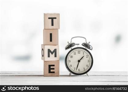 Time concept with a clock and a word on a wooden table