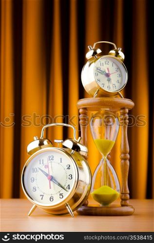 Time concept with alarm clock and hourglass