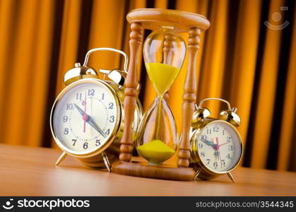 Time concept with alarm clock and hourglass