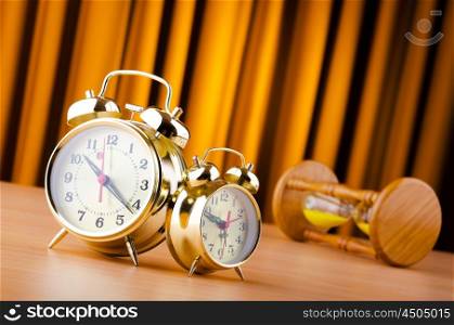 Time concept with alarm clock and hourglass