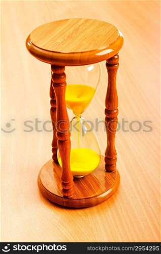 Time concept with hourglass on wooden background