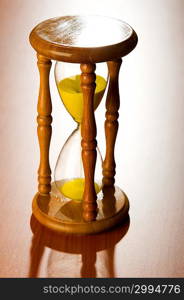 Time concept with hourglass on wooden background