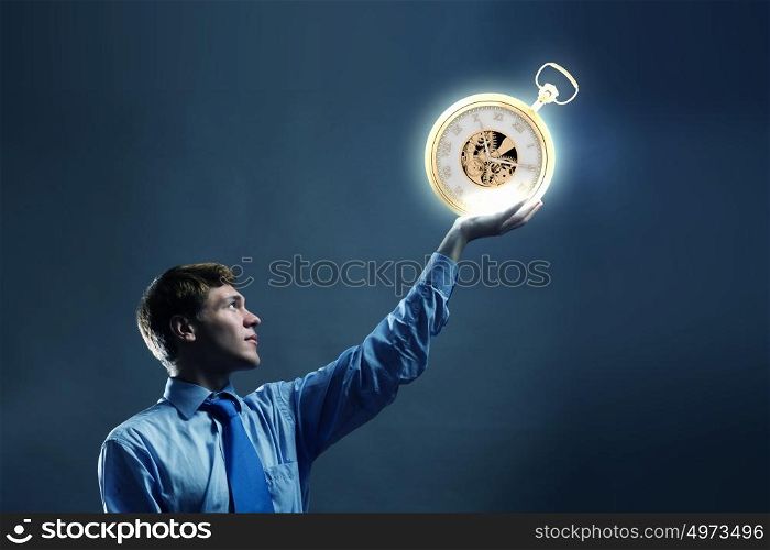 Time concept. Young businessman holding pocket watch in hand