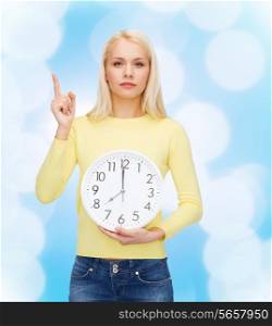 time, education and people concept - serious young woman with wall clock showing 8 and finger up