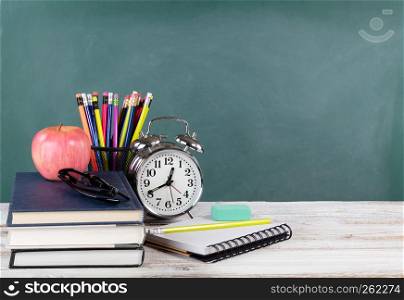 Time for back to school concept including books and stationery supplies with green chalkboard