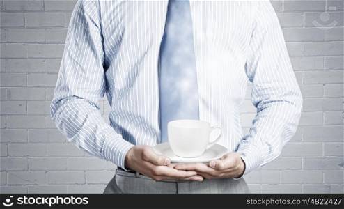Time for break. Close up of businessman holding in hands white cup