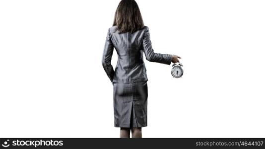Time for business. Back view of businesswoman holding alarm clock against white background