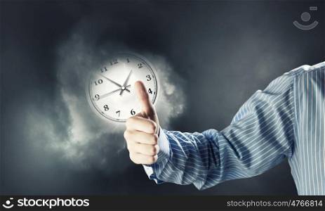 Time for business. Hand of businessman showing thumb up to time concept