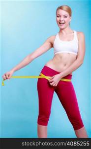 Time for diet slimming weight loss. Health care and healthy nutrition. Young fitness woman fit girl with measure tape measuring her loins on turquoise
