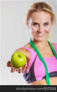 Time for diet slimming weight loss. Health care and healthy nutrition. Young fitness woman fit girl with measure tape and apple fruit on gray. woman fit girl with measure tape and apple fruit