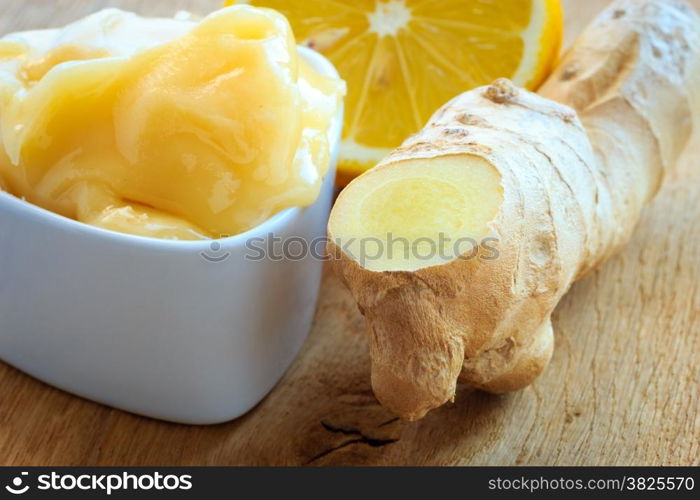 Time for make ginger tea. Fresh raw ginger rhizome root, honey and lemon on wooden rustic table.