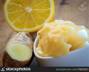 Time for make ginger tea. Fresh raw ginger rhizome root, honey and lemon on wooden rustic table.