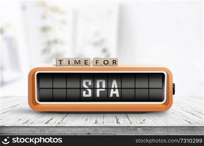 Time for spa message on a colorful alarm clock in a bright room with a wooden table