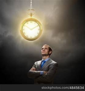 Time is money. Image of young businessman and pocket watch. Time concept