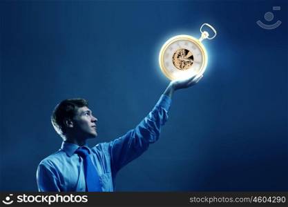 Time is money. Young businessman holding pocket watch in hand