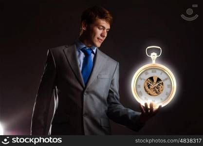 Time is money. Young businessman holding pocket watch in hand
