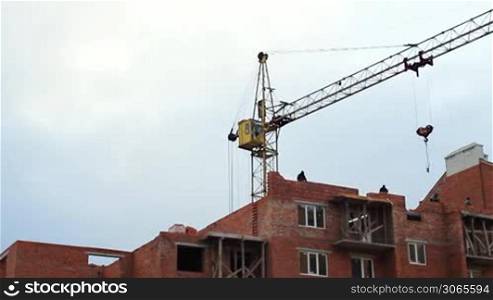 time-lapse construction activity, workers lay bricks, crane gives concrete lintel on windows