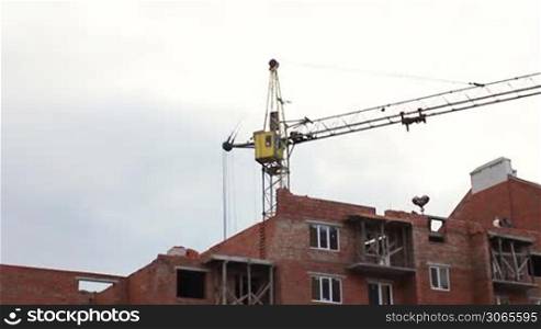 time-lapse construction activity, workers lay bricks, crane gives container with cement mortar