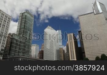 Time lapse, looking up at towering skyscrapers in Chicago with clouds and blue sky