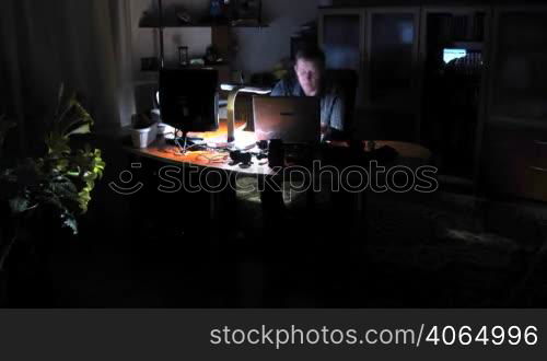 time lapse. man works on computer at night.