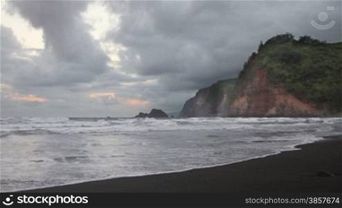 Time lapse of a Hawaiian coastline with cliffs and a rare black sand beach on a cloudy day