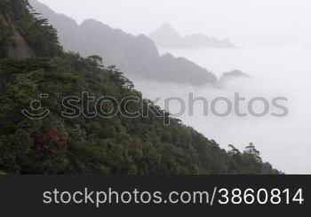 Time lapse of clouds crossing over mountain in the rain.