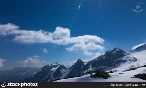 Time-lapse of clouds on the snow and cloudy mountains in Alps, Austria. In the sky flying airplane