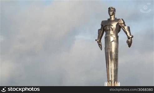 Time lapse of clouds running behind monument to Yuri Gagarin. Metal statue of famous Russian cosmonaut in Moscow. Wide shot.