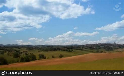 Time-lapse of cloudy sky over fields with beautiful scenic nature in the village in Italy, Tuscany