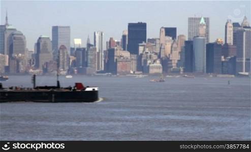 Time lapse of industrial ships passing by, Manhattan in the background