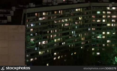 Time lapse of multistorey building with changing window lighting at night.