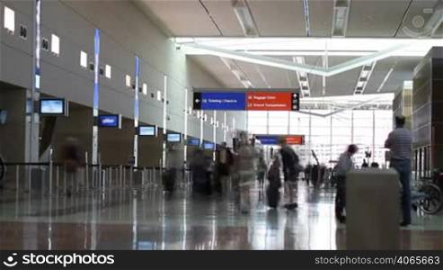Time Lapse of people with luggage, walking and checking in at an airport