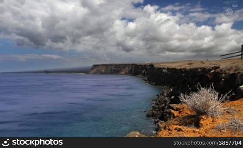 Time lapse of the coastline of the southernmost point in the USA, lined with steep cliffs dropping off into the blue pacific ocean