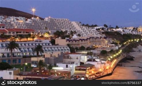Time Lapse of the village of Morro Jable, Fuerteventura - Canary Islands. Lots of hotels and a crowdy beach, sun goes down.