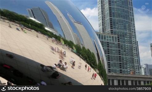Time lapse of tourists exploring Millennium Park in the reflection of the Cloud Gate sculpture, with the Chicago skyline.