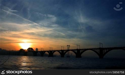time lapse. railway bridge against an evening city.