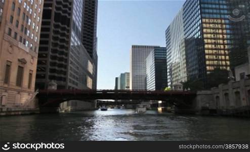 Time lapse shot from a boat as it passes underneath bridges and past the skyscrapers of Chicago on the Chicago River