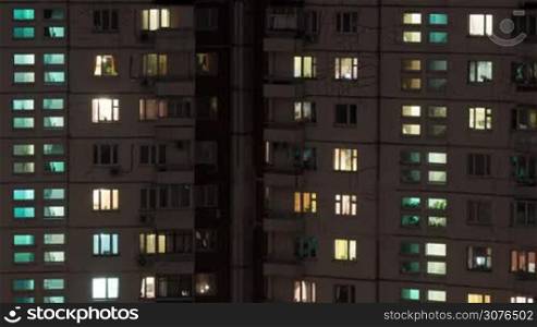 Time lapse shot of buildings and lighted and dark windows at night