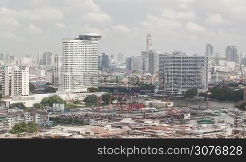 Time lapse shot of construction building area on the foreground and cityscape with skyscraper on the background, Bangkok, Thailand