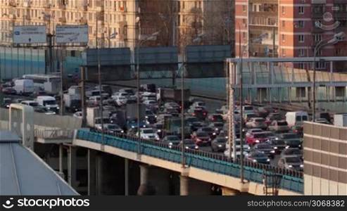Time lapse traffic congestion on an urban flyover during rush hour traffic as cars drive nose to tail in the early evening as commuters return home