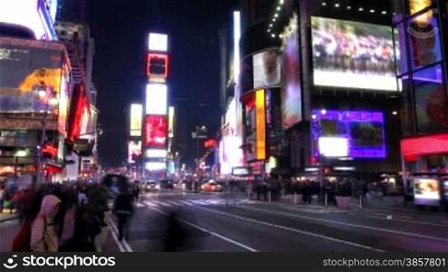 Time lapse with busy street and sidewalk in Times Square at night.