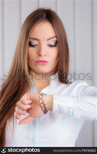Time management. Beautiful woman showing the time on her wrist watch indoor