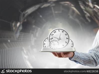 Time management concept. Businessman hold tablet pc with clocks on screen