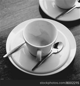 Time to reflect over a empty coffee cup in black and white