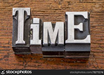 time word in vintage metal type printing blocks over grunge wood