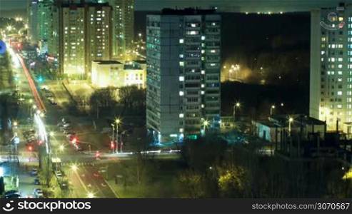 Timelapse and high angle view of big city life at night. Illuminated streets with intense traffic and multistorey buildings