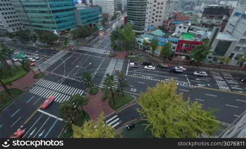 Timelapse high angle shot of transport traffic on junction in capital city Seoul, South Korea. Road marked with zebra crossings
