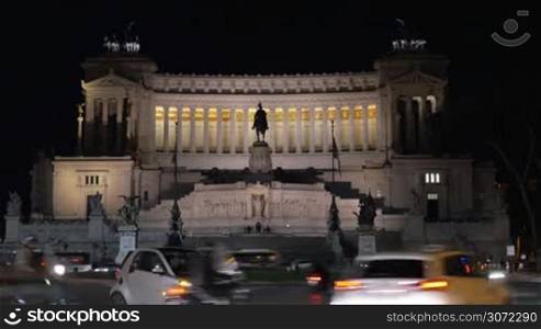 Timelapse of cars passing by historic monument Altar of Fatherland at night. Sightseeing of Rome, Italy