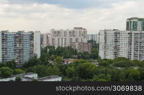 Timelapse of changing cloudscape over the residential area in the city. View with following distance