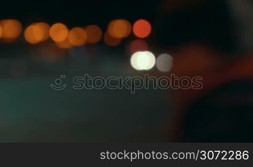 Timelapse of traffic lights in the city at night. Defocused shot of moving cars and people